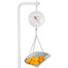 A Cardinal Detecto hanging scoop scale with a bowl of oranges.