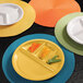 A yellow Elite Global Solutions melamine plate with four compartments, filled with vegetables.