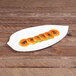 An Elite Global Solutions leaf-shaped white melamine platter with sliced papaya on it.