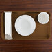 A brown rectangular Cambro tray with a white plate and a white cup on it.