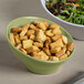 An Elite Global Solutions Weeping Willow green melamine bowl filled with croutons next to a bowl of salad.