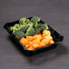 A black rectangular melamine dish with broccoli and carrots.