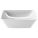 An Elite Global Solutions white square melamine bowl with a curved edge.