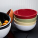 A white Elite Global Solutions melamine bowl filled with oranges on a counter.