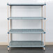 A white metal MetroMax Q shelf with a white metal grate with holes.