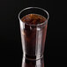 A Fineline clear hard plastic crystal tumbler filled with cola and ice on a black surface.