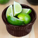 A Tablecraft Midnight Speckle cast aluminum souffle bowl filled with lime wedges.