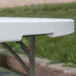 A close-up of a Flash Furniture white plastic folding table.
