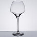A clear Chef & Sommelier wine glass with a stem on a table.
