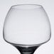 A clear wine glass with a black base.