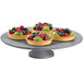 A Tablecraft granite cast aluminum round platter with fruit on it.