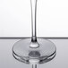 A close-up of a Chef & Sommelier round wine glass filled with clear liquid.