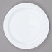 An Arcoroc white glass side plate with a white rim on a gray surface.