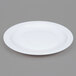 An Arcoroc white narrow rim side plate on a gray background.