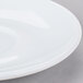 An Arcoroc white saucer with a rim.