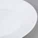 An Arcoroc white opal glass lunch plate with a white rim.