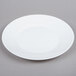 A white Arcoroc glass lunch plate with a white rim on a gray surface.