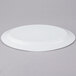 An Arcoroc white oval platter on a gray surface.