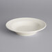 A Tuxton Reno eggshell china soup bowl on a gray surface.