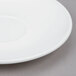 A white Arcoroc saucer with a small rim.
