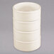 A stack of Tuxton eggshell white china bowls.