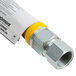 A stainless steel gas connector hose with a yellow nozzle and metal nut.