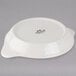 A white Tuxton round shirred egg dish with a lid.