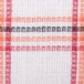 A close up of a white and orange striped waffle-weave fabric dish cloth.