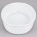 A white oval deep dish porcelain serving platter on a gray surface.