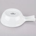A white porcelain bowl with a handle.