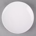 A CAC bone white porcelain plate with a white rim on a gray surface.