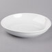 A Tuxton white porcelain pasta bowl on a gray surface.