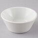 A Tuxton porcelain white soup bowl on a gray surface.