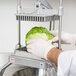 A person using a Nemco Easy LettuceKutter to cut a head of lettuce.