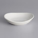 A close up of a Tuxton white oval china bowl on a gray surface.