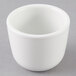 A Tuxton porcelain white Chinese sake cup on a gray surface.