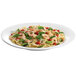 A Tablecraft white cast aluminum platter with a plate of pasta with shrimp and vegetables.