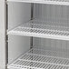A white Turbo Air glass door merchandising freezer with shelves inside.