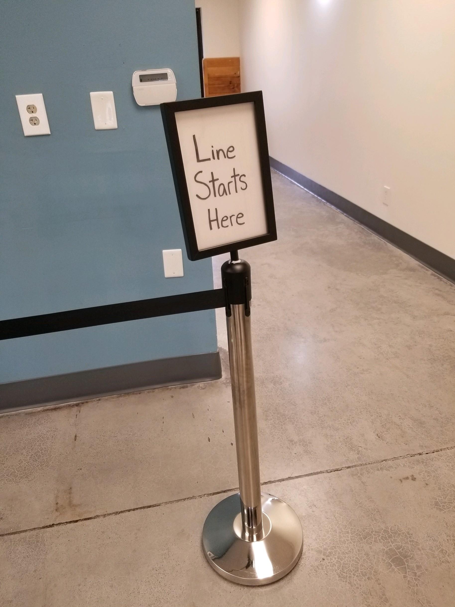 Sign telling customers where line starts