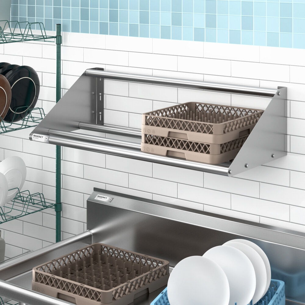 A stainless steel wall-mounted tubular rack shelf with two beige dish racks placed on it.