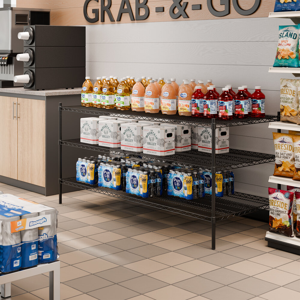 A black metal shelving unit with three shelves holding various beverages in a convenience store setting.