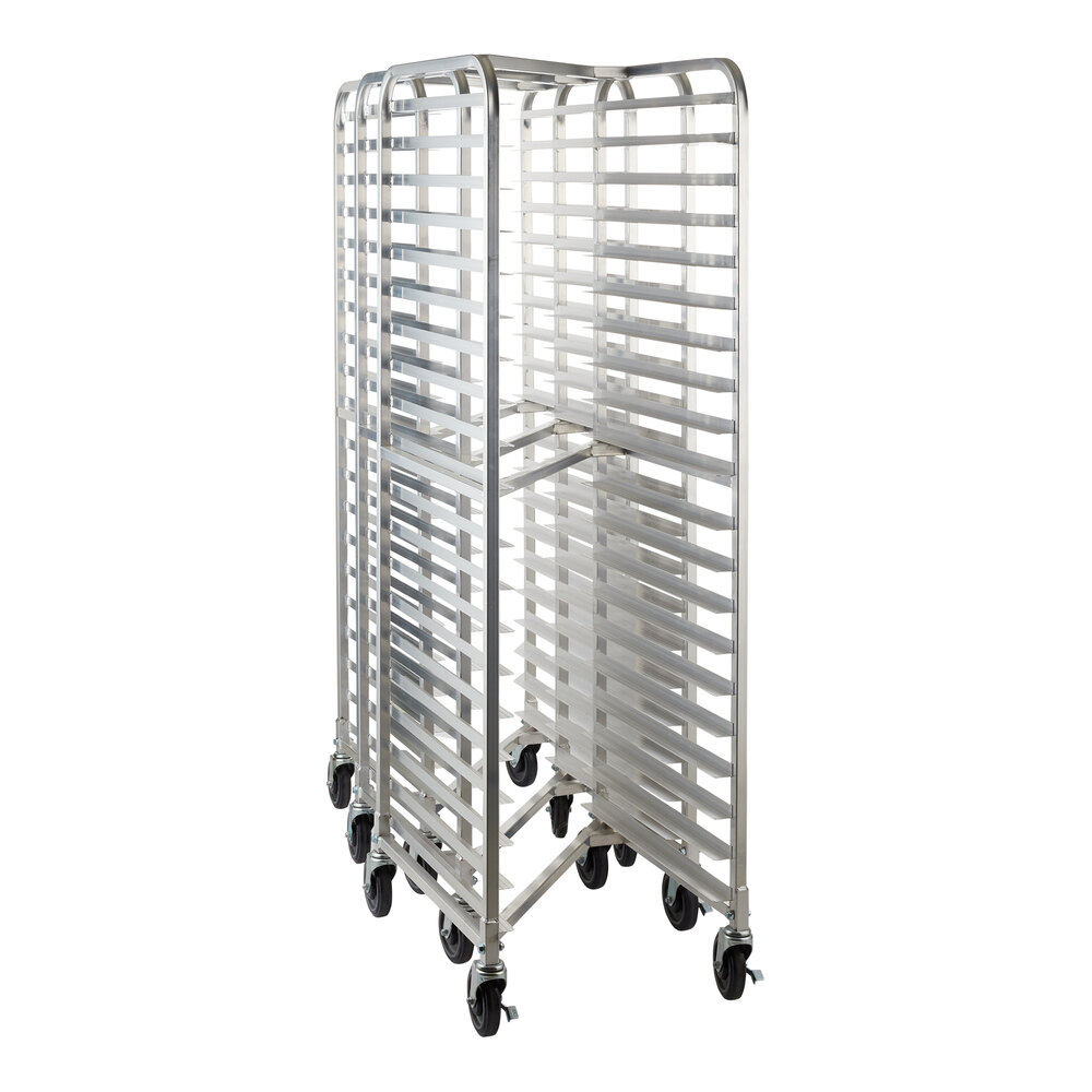 Three tall, metal racks with multiple horizontal slots and wheels, designed for holding trays or pans, are nested together.