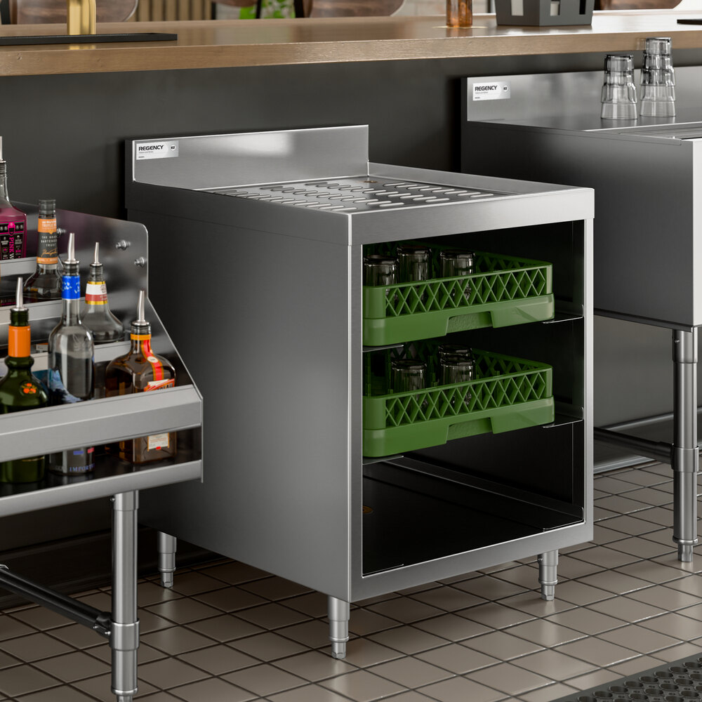 A stainless steel storage unit with a corrugated top and two green glass racks filled with glassware.