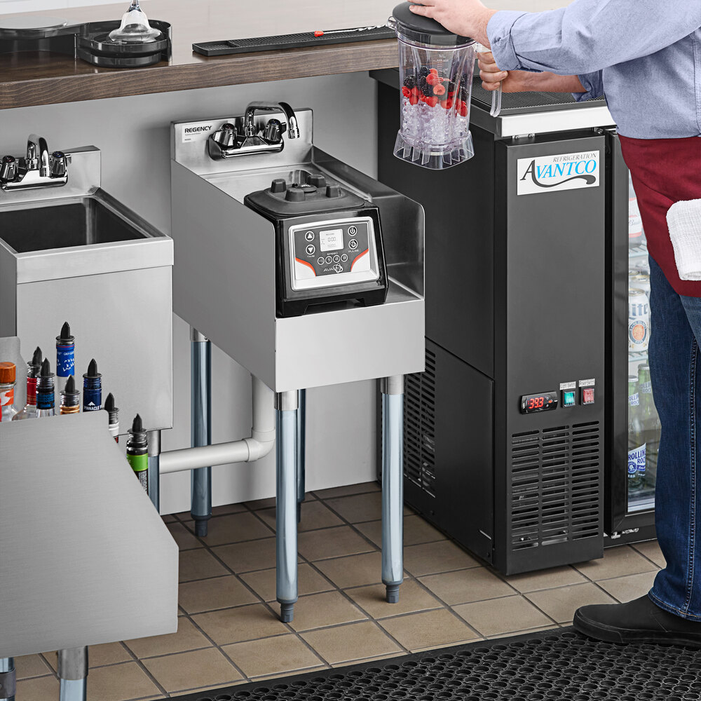 A stainless steel blender station with a built-in dump sink, shown with a blender and a person preparing ingredients.