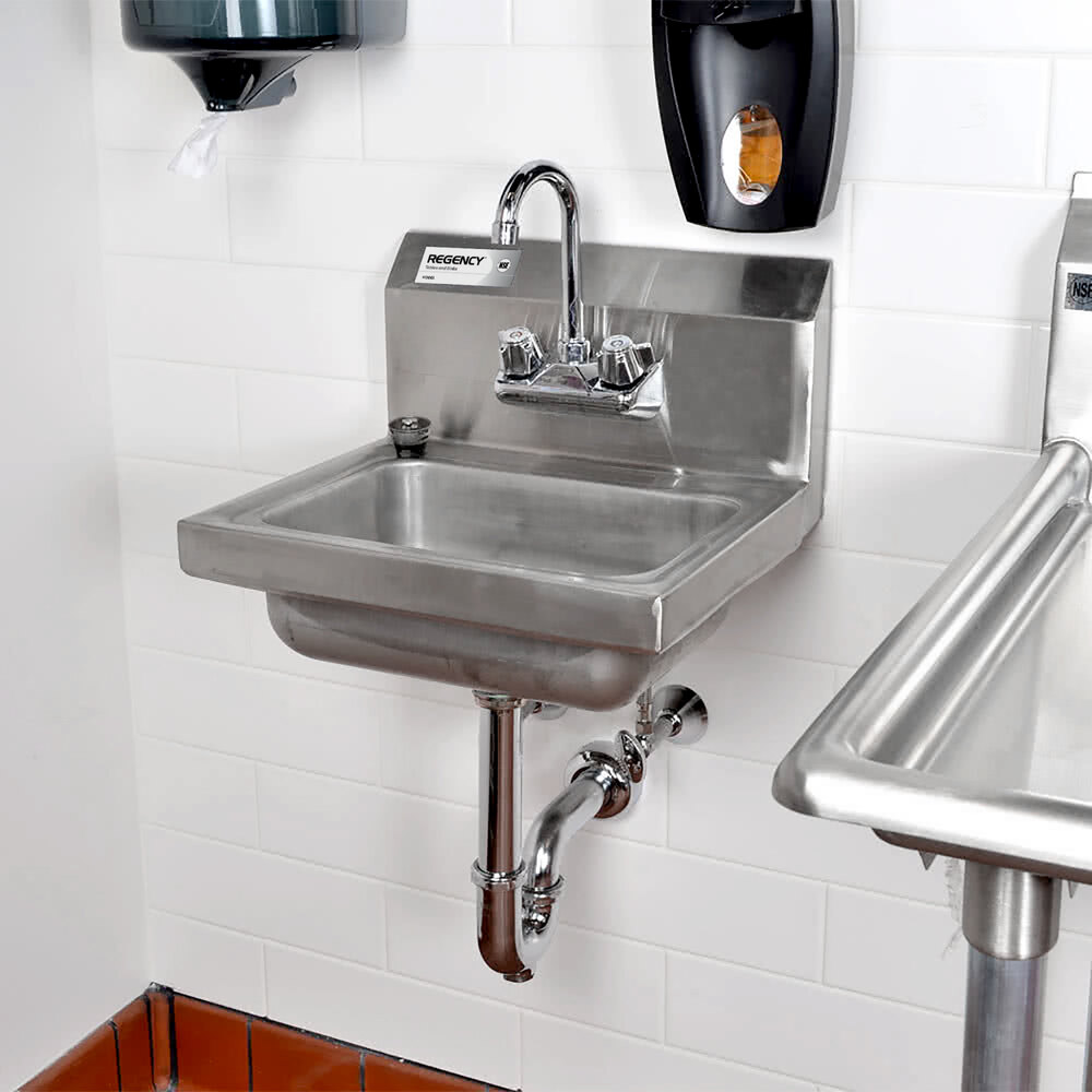 A stainless steel wall-mounted sink with a chrome P-trap and faucet, installed against a white tiled wall.