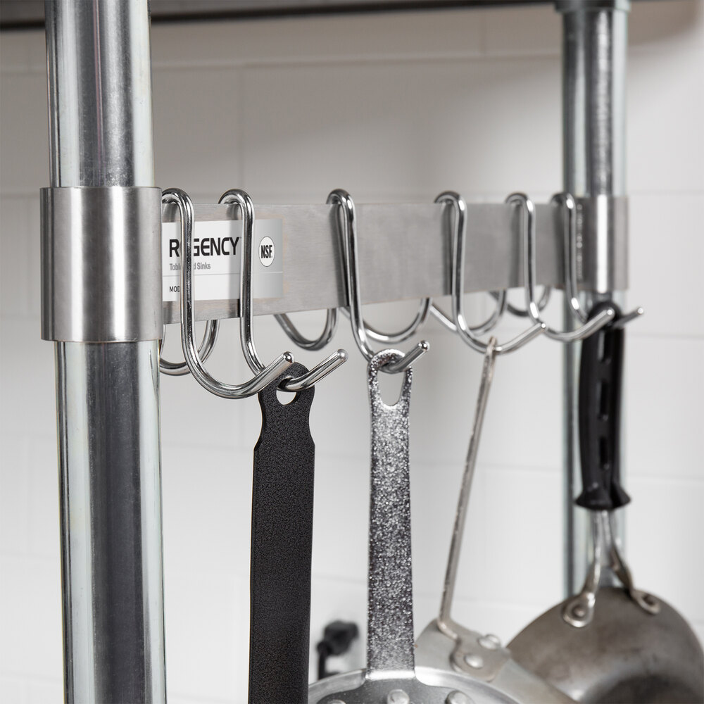 A metal rack with six double prong hooks is mounted between two vertical poles, holding various kitchen utensils and pans.