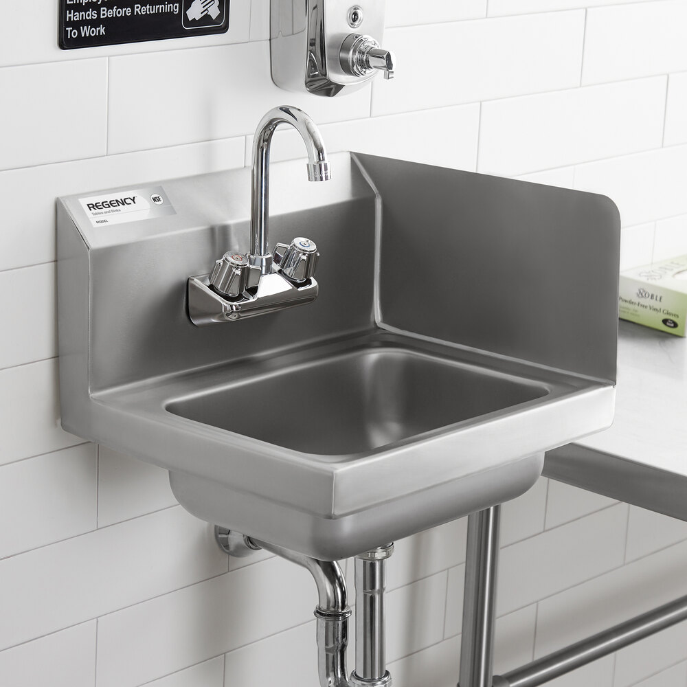 A stainless steel wall-mounted hand sink with a right-side splash guard and a gooseneck faucet, installed against a tiled wall.