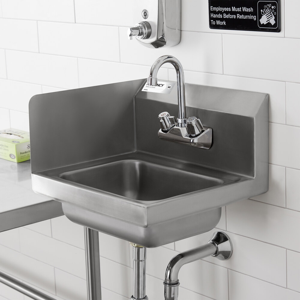 A stainless steel hand sink with a high backsplash and side splashes, mounted on a wall with visible plumbing underneath.