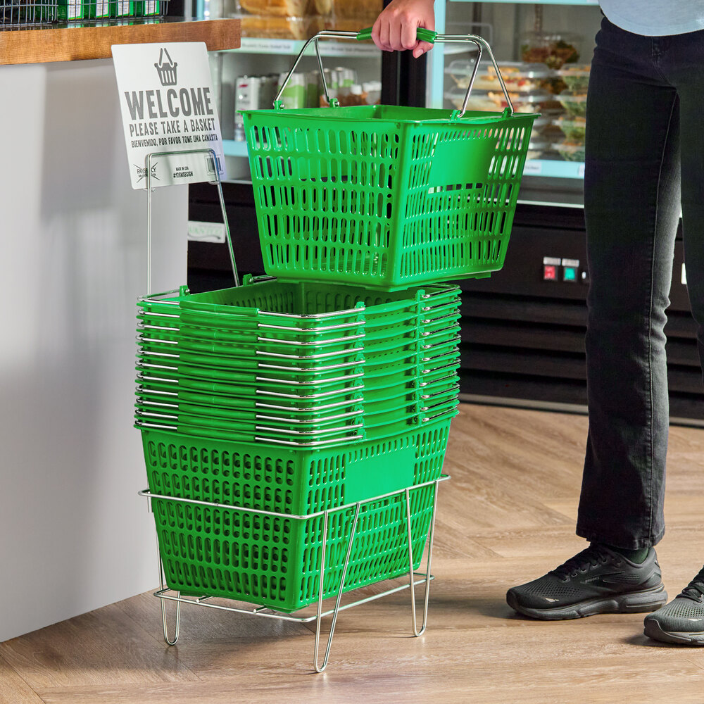 A stack of green plastic grocery market shopping baskets with metal handles, placed on a metal stand with an accompanying sign.