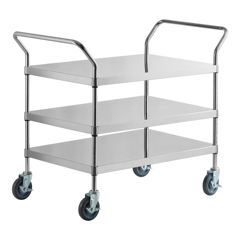 A three-shelf stainless steel utility cart with handles on both ends and four swivel caster wheels.